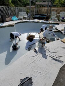 A bunch of people working on a pool wearing white shirts