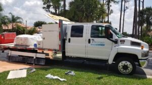 A truck standing on a road and being loaded with stuf