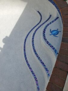 A closeup look of a pool concrete stair with a turtle made on it